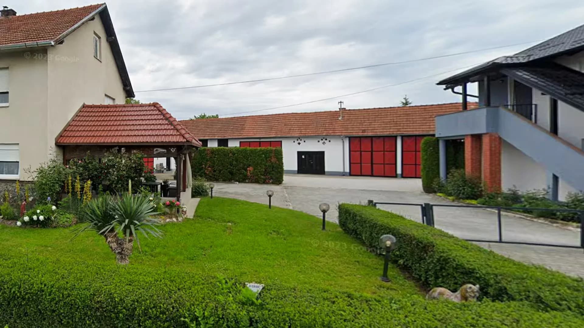 Dugačka gospodarska zgrada s crvenim vratima uz popločano dvorište, Novi Marof