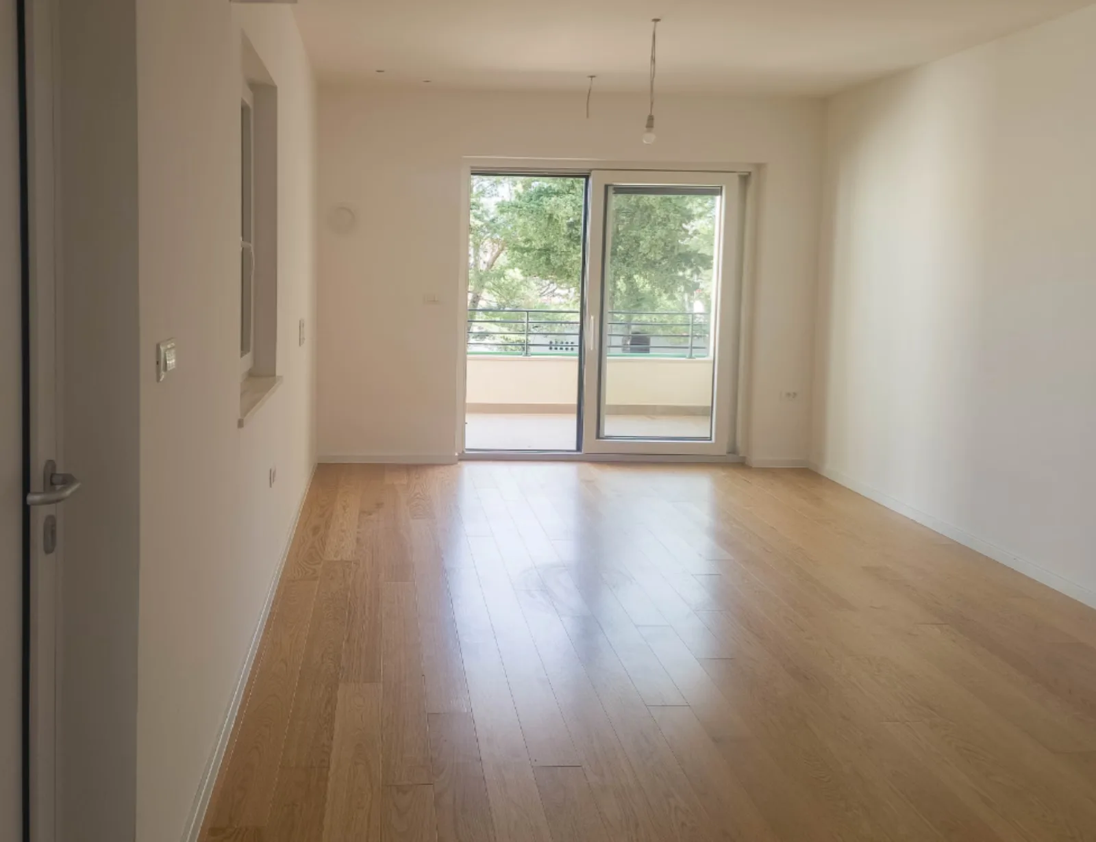 Prazna soba s parketom i izlazom na terasu, apartman na Malom Lošinju, 1. stan