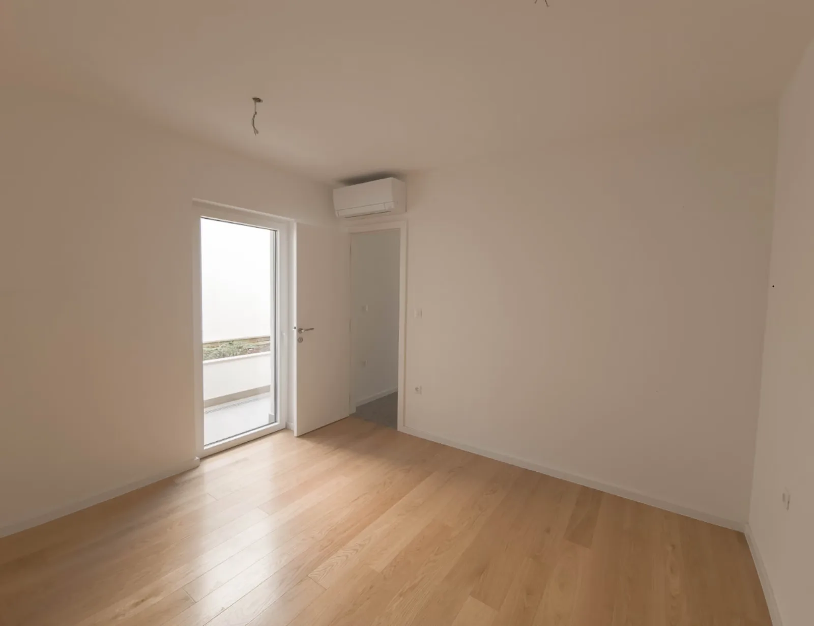Prazna soba s vratima na balkon, apartman na Malom Lošinju, 1. stan
