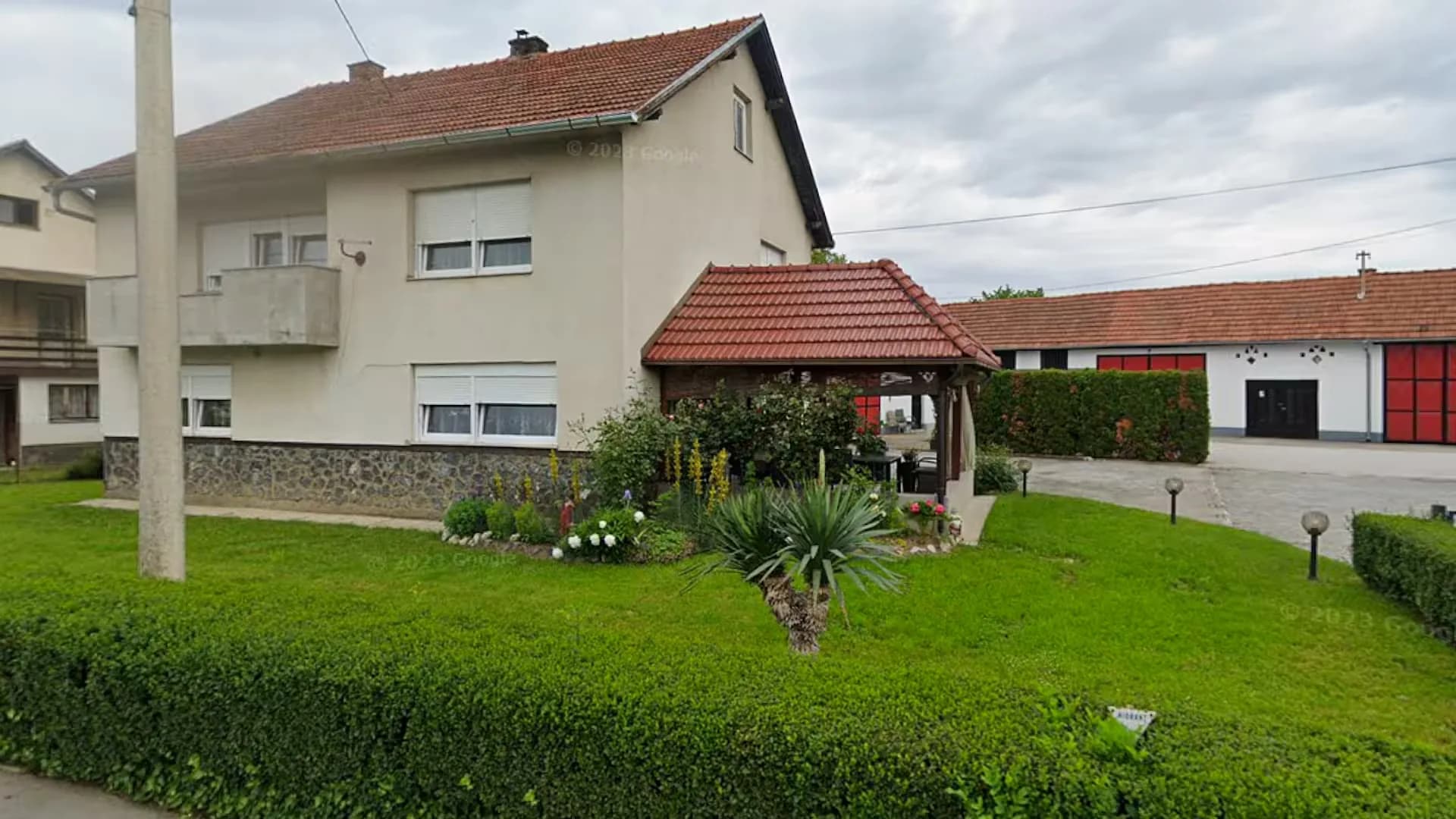 Uređeno dvorište s cvjetnjakom i drvenom sjenicom, kuća u Novom Marofu
